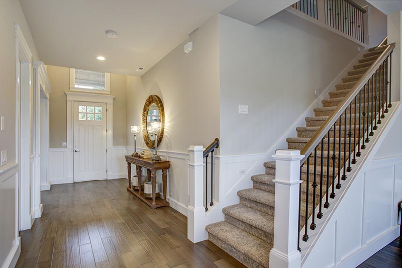 Foyer and staircase of a new house seen while preforming home inspection services 